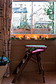 Lit candles and pine decorations on window ledge of London home UK