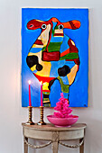 Multicoloured cow are and side table with lit candles in modern Odense family home Denmark