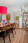 PInk lampshade hangs over dining table in modern Odense family home Denmark