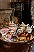 Teaset on tray with chocolate eclairs in Cheltenham country home Gloucestershire England UK