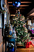Weihnachtsbaum und blaue Christbaumkugeln mit Vase auf Beistelltisch in Cheltenham Landhaus Gloucestershire England UK