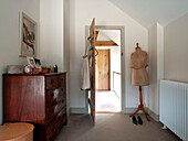 Wooden chest of drawers and mannequin in bedroom of Suffolk family home England UK