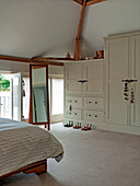 Full length mirror and storage area in bedroom of Suffolk family home England UK