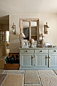 Salvaged window frame and wellington boots with painted sideboard in Canterbury home England UK