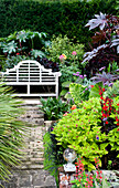 Bench seat in garden of rural Suffolk country house England UK