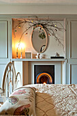 Twig arrangement above oval mirror in bedroom of Walberton home, West Sussex, England, UK