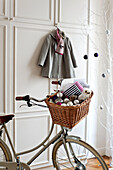 Baubles in bicycle pannier in hallway of Paris apartment, France
