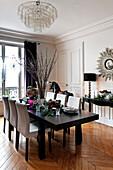 Twig arrangement centrepiece on black dining table of Paris apartment, France, at Christmas