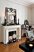 Snowflake Christmas decorations and vintage mirror in fireplace of Paris apartment, France