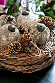 Frosted silver baubles and pine cones on placemats in Paris apartment, France