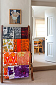 Bright fabric samples hang on rack in Hertfordshire home, England, UK