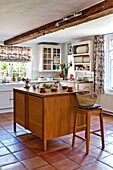 Wooden kitchen island in tiled kitchen of Hertfordshire home, England, UK