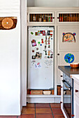 Kinderzeichnung und Erinnerungsfotos am Kühlschrank in einem Haus in Hertfordshire, England, UK
