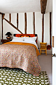 Quilted cover on double bed in timber framed Hertfordshire home, England, UK