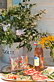 Rosa Limonade und Gläser mit Schnittblumen auf einem Tisch im Sonnenlicht, Haus in Essex, England, Vereinigtes Königreich