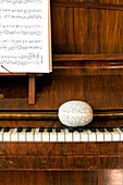 Easter egg on piano keys with sheet music in Essex home, England, UK