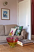 Glasschale und Bücher auf einem hölzernen Couchtisch im Wohnzimmer des Hauses der Familie Bovey Tracey, Devon, England, UK