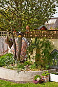 Garden ornaments with tree in back garden of Bovey Tracey, Devon, England, UK