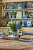 Blue and white ceramics with yellow tulips on table of Suffolk farmhouse kitchen, England, UK