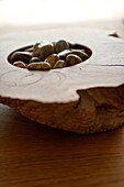 Smooth pebbles in driftwood in contemporary home, Cornwall, England, UK