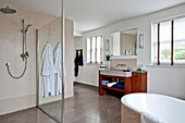 Bademäntel hängen in der geräumigen Nasszelle mit Duschabtrennung in einem modernen Haus, Cornwall, England, UK