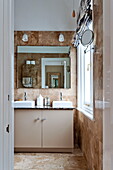 Spiegel über Doppelwaschbecken im Badezimmer eines Familienhauses in Middlesex, London, England, UK