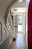 Eingangshalle und Treppenhaus mit offener Eingangstür in einem modernen Landhaus in Suffolk, England, UK