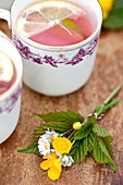 Cups with pink lemonade and posies of buttercups (Ranunculus) in Brecon, Powys, Wales, UK