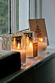 Scented candles with silver candle holders on windowsill of Shropshire cottage, England, UK