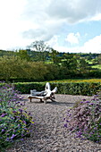 Gartensitzplatz auf Kies in ländlichem Garten, Blagdon, Somerset, England, UK