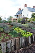 Raised flowerbeds and rural farmhouse exterior in Blagdon, Somerset, England, UK