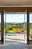 View through double doors to garden exterior of rural Blagdon home, Somerset, England, UK
