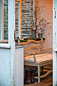 Bench seat and boots in porch of Crantock Cornwall England UK