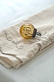 Vintage gold bauble on embroidered napkin in Penzance family home Cornwall England UK