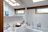 Weiß gefliestes Badezimmer mit Spiegelschrank in einem Haus in Cornwall, UK