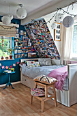 Single bed with striped duvet at window with photographs and postcards in child's room of East Grinstead family home West Sussex England UK