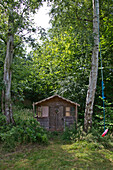 Wooden shed and rope swing in East Grinstead garden Sussex England UK