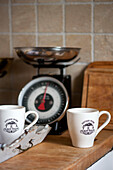 Teacups and kitchen scales with tray on worktop in Stamford home Lincolnshire England UK