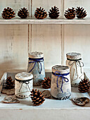 Fabric covered jars tied with string with pinecones and hearts on side unit London