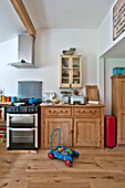 Toy truck in front of wooden sideboard and oven with extractor in Cambridge cottage England UK