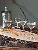 Cocktail glasses with vintage storage tin on wooden tabletop in London home England UK