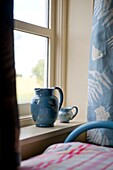 Blue ceramic jugs on windowsill in Edworth bedroom Bedfordshire England UK