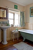 Freistehende Badewanne und Sockel mit offenem Fenster in einem Badezimmer in Edworth, Bedfordshire, England, UK