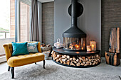 Modern fireplace with yellow two seater in Lechlade living room Gloucestershire England UK