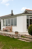 Croquet set and wooden seat on stone terrace of Cornwall beachhouse extension England UK