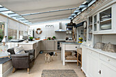 Leather armchair in kitchen extension of Penzance farmhouse with pet dog Cornwall England UK