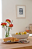 Rote Freesien und Zitrone mit Kuchen auf Küchenarbeitsplatte in Familien-Stadthaus in Cornwall England UK