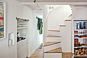 Wooden staircase with recessed shelving in hallway of family townhouse Cornwall England UK