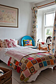 Crochet blanket on single bed in girl's room of Cornwall cottage UK
