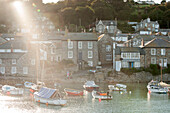 Moored boats in coastal harbour Mousehole fishing village Cornwall UK